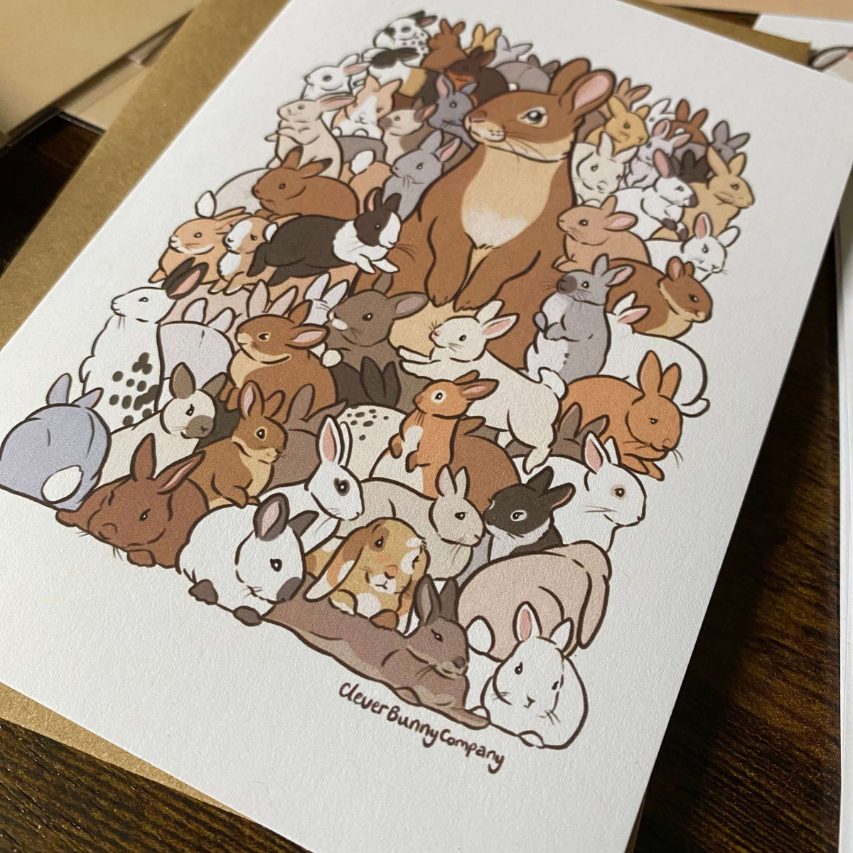 Greetings card featuring an illustration of lots of baby rabbits in different colours, surrounding a parent rabbit.