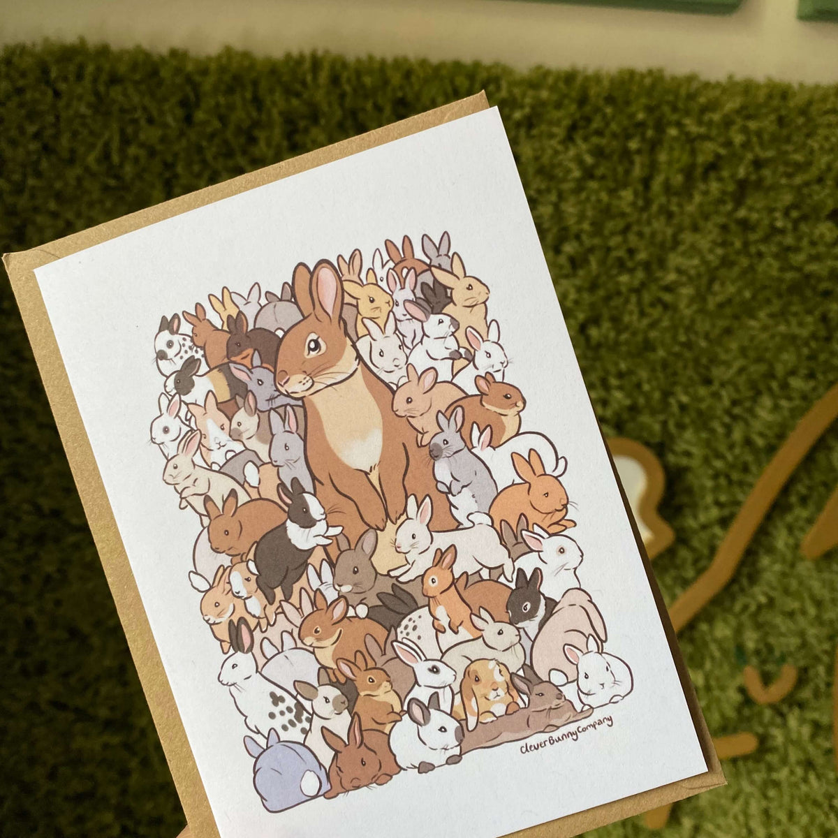 Greetings card featuring an illustration of lots of baby rabbits in different colours, surrounding a parent rabbit.
